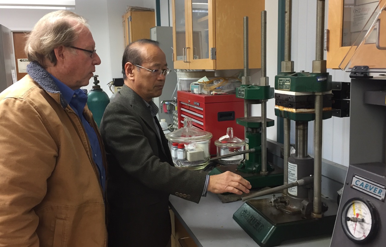 Professor Ishida demonstrates the Carver molding press for film director, John E. Maher